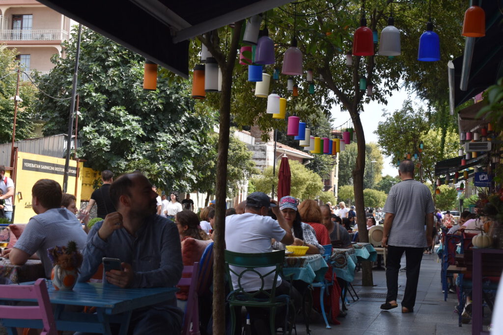 Cafe mit bunten Stühlen und Lampions an der Markise