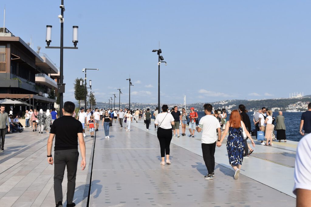 Passanten laufen entlang der Promenade im Galataport