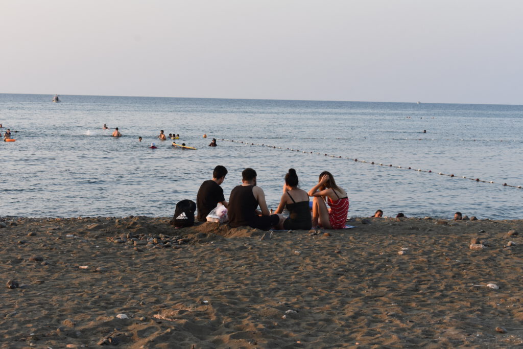 Teenager sitzen am Strand von Arsuz