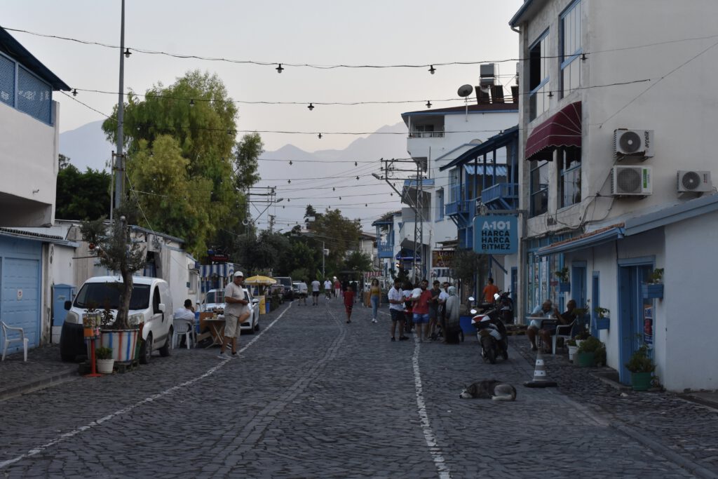 Spaziergänger flanieren in einer szenischen Gasse in Arsuz