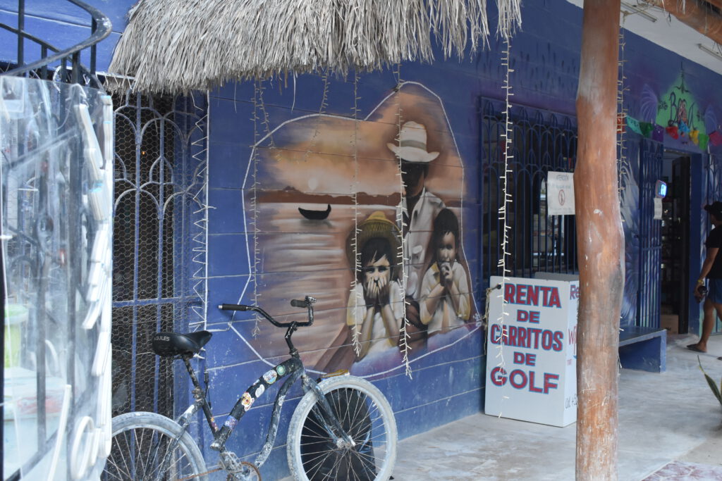 Gemälde einer Fischerfamilie auf einem blauen Haus auf der Isla Holbox
