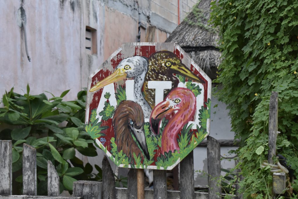 Stoppschild, auf das vier Vögel gemalt worden sind