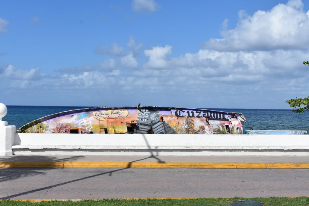Bunt bemaltes Wrack eines Boots an der Küste von Cozumel