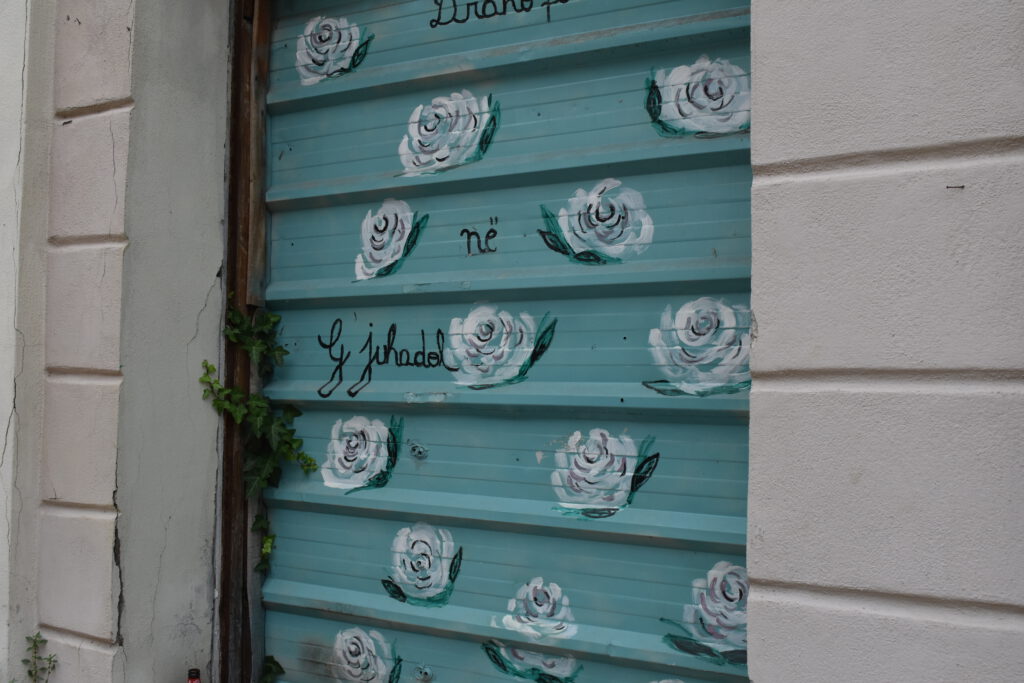 Graffiti mit weißen Rosen auf einem himmelblauen Untergrund
